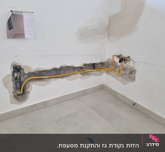 צינור גז צהוב מותקן בקיר עם חיבורי מתכת